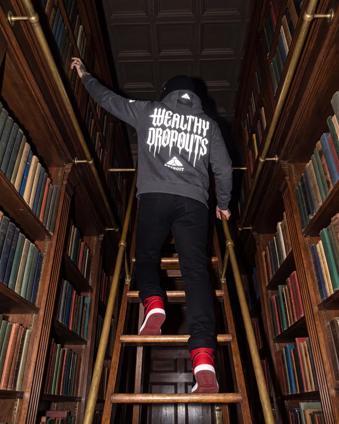 Charcoal heather, seen from the floor: high on a library ladder, reaching for a book
