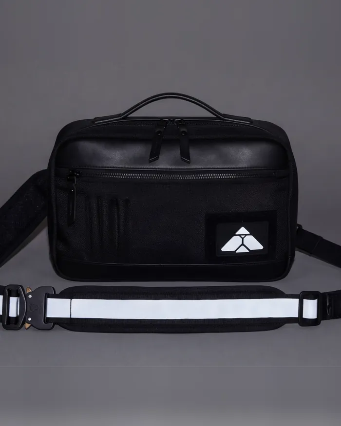 The sling under a flash: the stripe along the strap and the mark lit white