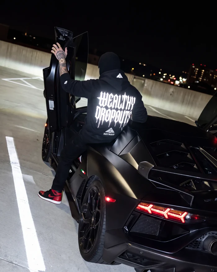 Tuition worn stepping into the black Lamborghini at night