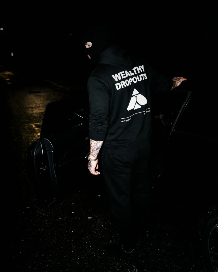 The Audit worn at a car door at night, the back print lit by the flash